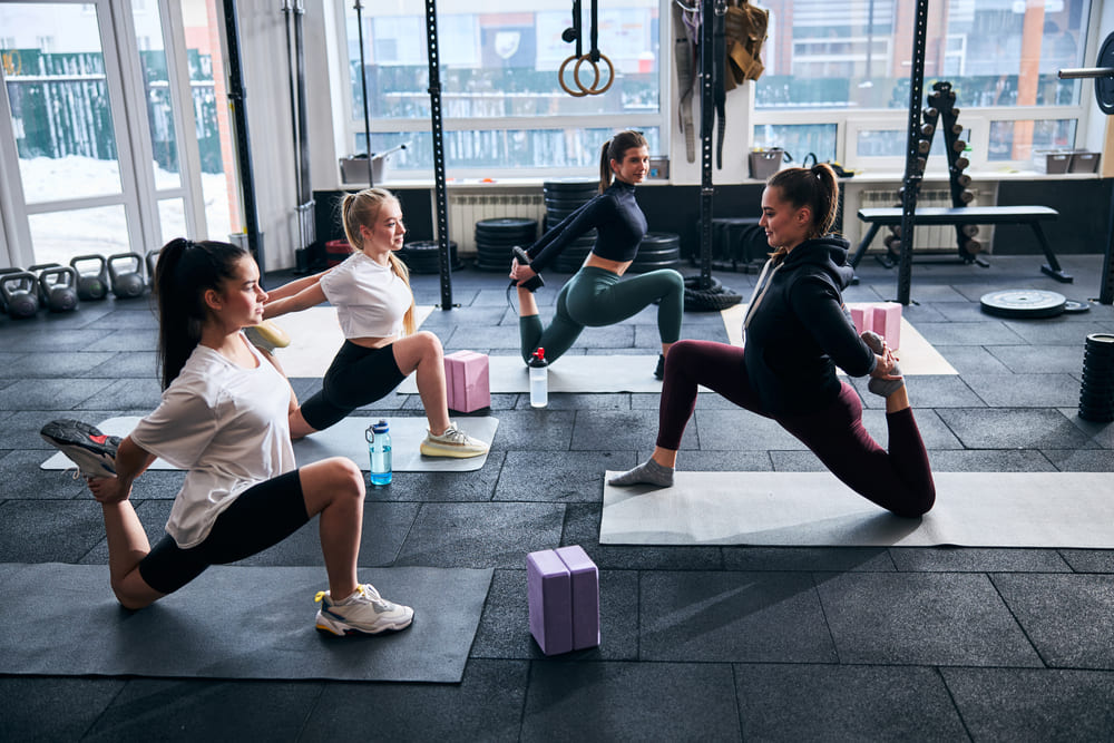 vriendinnen stretchen samen in de sportschool