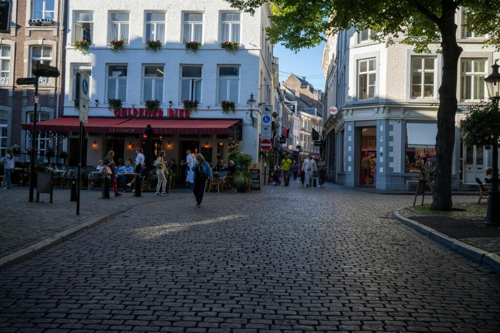 Gezellige straat met terras en mensen op plein tussen historische gebouwen in Maastricht