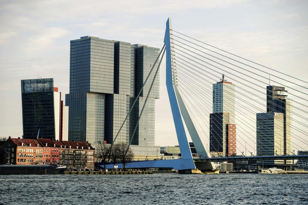 Erasmusbrug in Rotterdam met moderne skyline en gebouwen aan het water