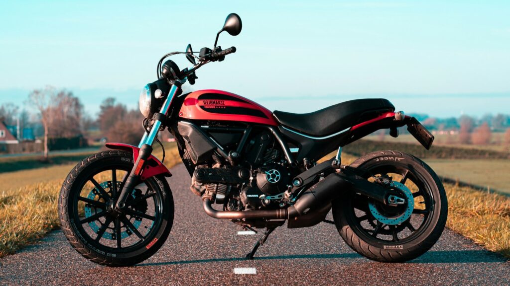 Rode Ducati Scrambler motor op een landweg tijdens een motorroute door Noord-Brabant